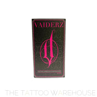 front view of the vaiderz tattoo needle cartridges box. black box with pink writing. the classic vaiderz logo is front and center of the box. ornamental light grey pattern in the background of the tattoo needle cartridge box.